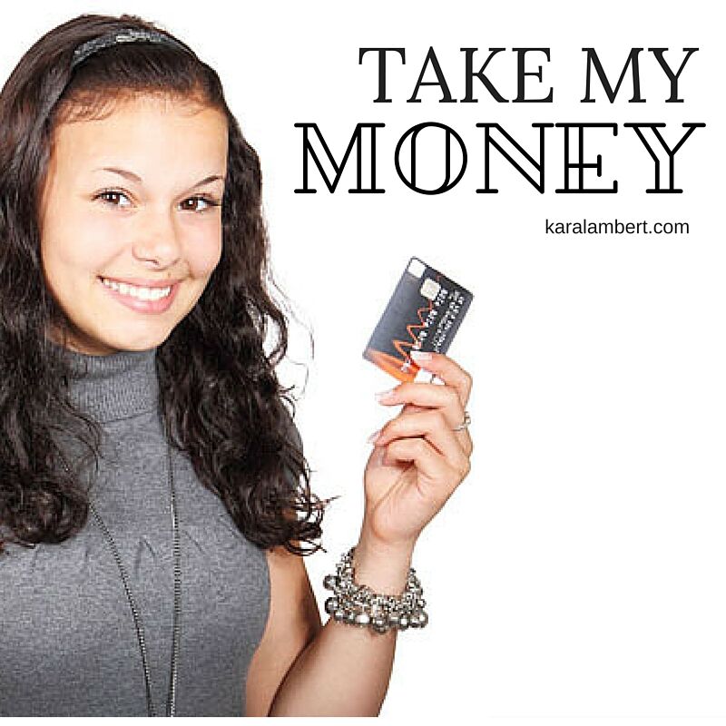 A girl displaying a credit card enthusiastically.
